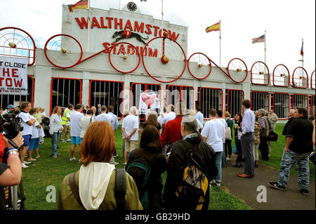 Un gruppo di dimostranti si riuniscono fuori dall'ingresso principale dello stadio di Walthamstow, per unirsi a una marcia al Municipio di Waltham Forest per protestare contro la chiusura del noto stadio. Foto Stock