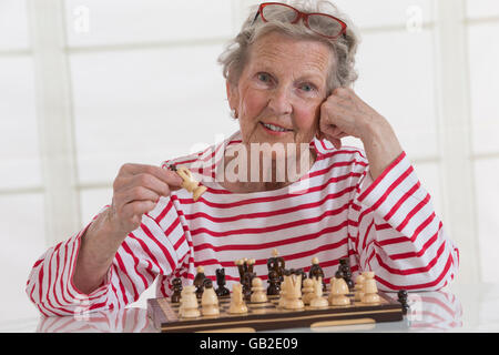 Senior donna giocando a scacchi Foto Stock