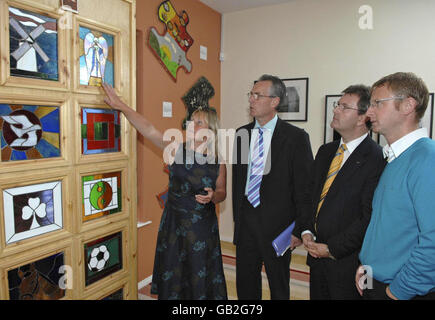 Sandra Peake, Chief Executive del Wave Center (a sinistra) e Manager Alan McBride (a destra) mostra una vetrata, realizzata da uomini che frequentano il Wave Trauma Center, al ministro junior Gerry Kelly MLA (seconda a sinistra) e al ministro junior Jeffrey Donaldson MLA (seconda a destra) Durante la loro visita al Centro a nord di Belfast. Foto Stock