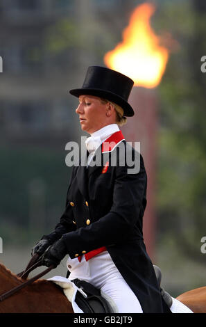 Sharon Hunt della Gran Bretagna che corre sulle navi cisterna la città passa davanti alla torcia olimpica durante l'evento di dressage il secondo giorno delle Olimpiadi di Pechino 2008 che si tengono al centro equestre di Shatin, Hong Kong. Foto Stock