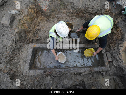 Gli archeologi della Durham University sollevano il coperchio di un sarcofago romano in pietra, scoperto in uno scavo sul sito di una ex cappella e edifici di uffici. Foto Stock