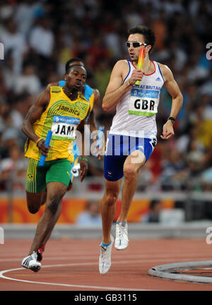 Il Martyn Rooney della Gran Bretagna guarda oltre la spalla alle camere Ricardo della Giamaica durante il relè da uomo 4x400m si riscalda allo Stadio Nazionale di Pechino durante i Giochi Olimpici di Pechino 2008 in Cina. Foto Stock