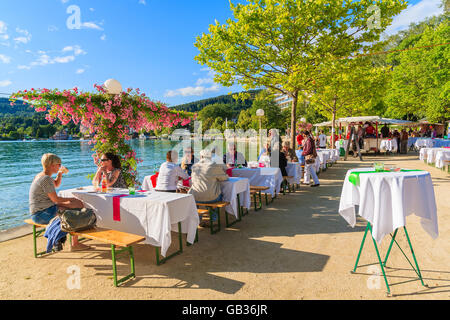 WORTHERSEE LAGO, Austria - giu 20, 2015: la gente seduta a tavoli lungo Worthersee lake shore durante l'estate del festival della birra. Foto Stock