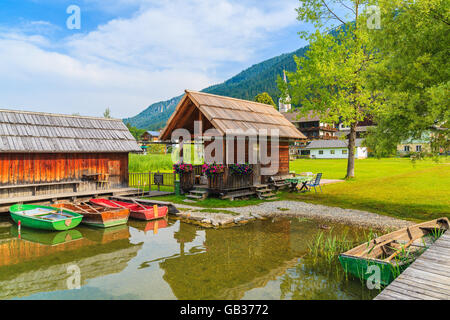 Barche da pesca e cabine in legno sulla riva del lago Weissensee in estate paesaggio del Land della Carinzia, Austria Foto Stock