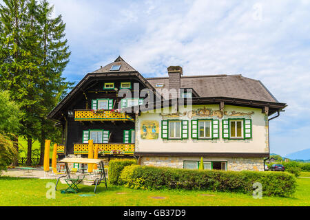 Lago Weissensee, Austria - Lug 6, 2015: tipico alpino guest house sul prato verde in estate paesaggio del lago Weissensee, Austr Foto Stock