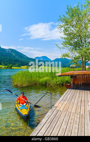 Lago Weissensee, Austria - Lug 6, 2015: un uomo in kayak sulle acque del lago Weissensee in estate il paesaggio di montagna delle Alpi, Austri Foto Stock