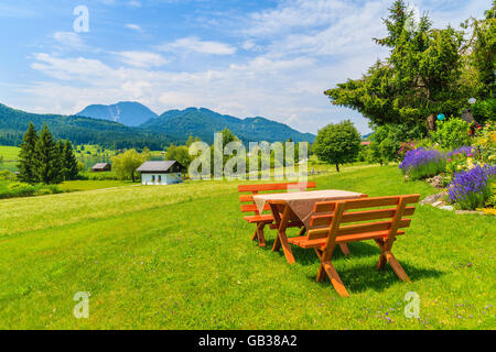 Panche con tavolo da picnic sul prato verde nel villaggio alpino sulle rive del lago Weissensee in estate il paesaggio di montagna delle Alpi, Au Foto Stock