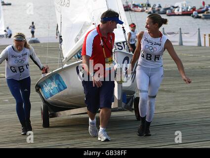 Christina Bassadone (destra) e Saskia Clark (sinistra) della Gran Bretagna trainano la loro barca dal porto dopo la serie di apertura RS:X delle donne al Centro di vela dei Giochi Olimpici di Pechino 2008 a Qingdao, Cina. Foto Stock