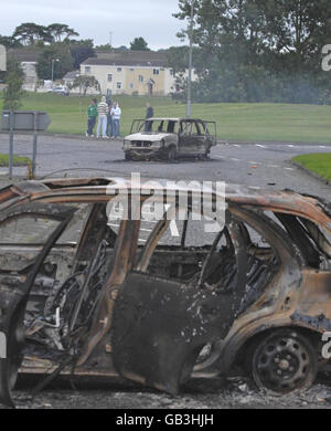 SI PREGA DI NOTARE CHE I VOLTI SONO STATI PIXELATI DAL PA PICTURE DESK. Una visione generale delle automobili bruciate nella tenuta di Tullygally a Craigavon, dopo che la polizia è stata pelata da bombe a benzina e altri missili. Foto Stock