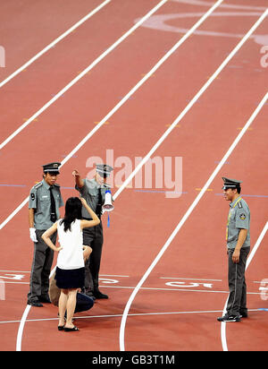 I volontari vengono sgomberati dalla pista mentre il programma di eventi termina allo Stadio Nazionale durante i Giochi Olimpici di Pechino 2008, Cina. Foto Stock