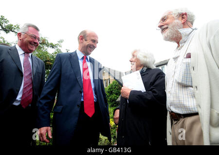 Il ministro del recupero delle inondazioni John Healey, secondo a sinistra, parla con i medici in pensione, Elsth e Derick Wilkinson fuori dalla loro casa danneggiata dalle inondazioni a Morpeth, Northumberland, con il deputato per Wansbeck, Denis Murphy, a sinistra, guardando avanti. Foto Stock