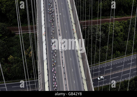 I piloti attraversano il ponte Humber durante la quinta tappa della gara ciclistica Tour of Britain. Foto Stock