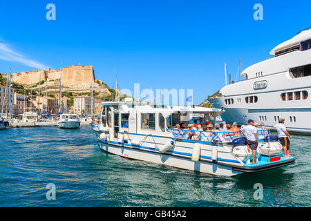 Porto di Bonifacio, Corsica - giu 25, 2015: imbarcazione turistica con i turisti in barca a vela al di fuori del porto di Bonifacio con cittadella in costruzione Foto Stock