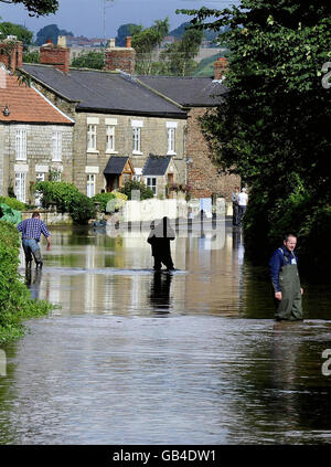 Una vista generale di Sinnington, North Yorkshire, dove gli abitanti del villaggio trovano la strada principale attraverso il loro villaggio sotto acque profonde alluvioni oggi a seguito di precipitazioni torrenziali. Foto Stock