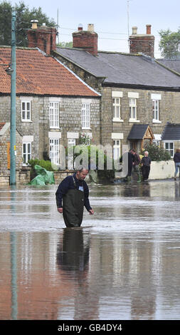 Una vista generale di Sinnington, North Yorkshire, dove gli abitanti del villaggio trovano la strada principale attraverso il loro villaggio sotto acque profonde alluvioni oggi a seguito di precipitazioni torrenziali. Foto Stock