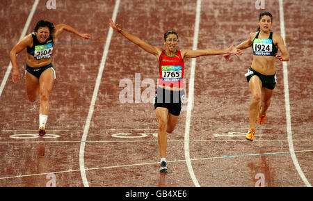 La Sanaa Benhama del Marocco festeggia dopo aver vinto la finale delle donne 100M T13 davanti a Maryna Chyshko dell'Ucraina (a sinistra) e al vincitore della medaglia d'argento Lise Hayes del Sud Africa (a destra) nello Stadio Nazionale, a Pechino, in Cina. Foto Stock