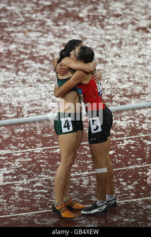 Il Marocco Sanaa Benhama celebra dopo aver vinto il T13 DA 100 M femminile con il vincitore della medaglia d'argento Lise Hayes del Sudafrica (a sinistra) nello Stadio Nazionale, a Pechino, in Cina. Foto Stock