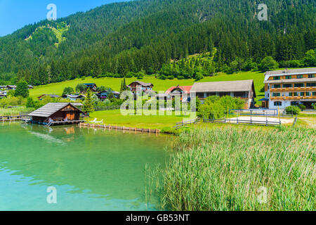 Houses on shore of beautiful Weissensee alpine lake in summer landscape of Alps Mountains, Austria Foto Stock