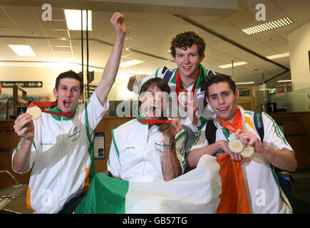 I membri del team irlandese Paralimpico, vincitore di medaglie, da sinistra a destra, Michael McKillop, Gay Shelly, Darragh McDonald e Jason Smyth, dopo aver toccato il suolo di casa, inginzagliando una serie di medaglie all'aeroporto di Dublino. Foto Stock