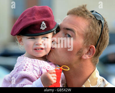 Lance Bombardier Martin Cartwright bacia la sua figlia di 18 mesi Faye dopo il suo ritorno a Merville Barracks a Colchester, dopo un tour di servizio in Afghanistan. Foto Stock