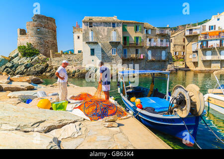 ERBALUNGA PORTA, CORSICA - Lug 4, 2015: pescatore reti di pulizia nel piccolo porto di Erbalunga. Questo piccolo villaggio di pescatori è Foto Stock