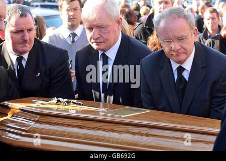 Il vice primo ministro dell'Irlanda del Nord, Martin McGuinness, a destra, aiuta a sollevare la bara di sua madre, Peggy McGuinness, 84, alla sua Messa di Requiem nella chiesa di San Columba, Long Tower, a Derry. Peggy McGuinness, 84 anni, morì lunedì nella sua casa di Elmwood Street a Bogside. Foto Stock