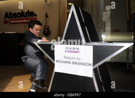 Il giorno in cui Absolute radio (ex Virgin radio) lancia, guardia di sicurezza della stazione Doug, ruota fuori il famigerato logo Virgin radio per essere inviato di nuovo a Virgin's Richard Branson, in One Golden Square, nel centro di Londra. Foto Stock