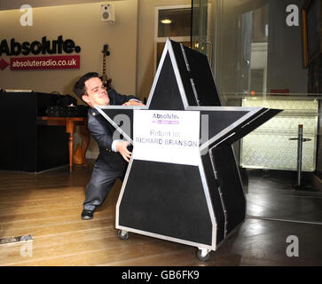 Il giorno in cui Absolute radio (ex Virgin radio) lancia, guardia di sicurezza della stazione Doug, ruota fuori il famigerato logo Virgin radio per essere inviato di nuovo a Virgin's Richard Branson, in One Golden Square, nel centro di Londra. Foto Stock