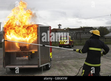 Il combattente del fuoco Jim o'Brian dimostra i pericoli di versare acqua su un fuoco di una padella durante il lancio della settimana della sicurezza antincendio, presso il Fire Brigade Training Center di Dublino. Foto Stock