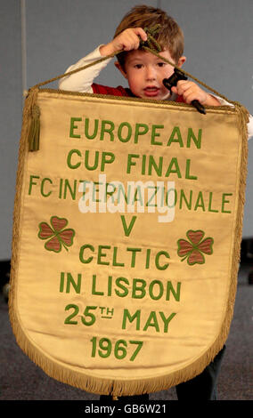 Hugh Convery, 4, aiuta in anteprima davanti all'asta del pennant ufficiale Celtic FC dalla finale della Coppa Europa 1967. Foto Stock