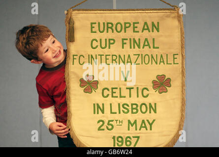 Hugh Convery, 4, aiuta in anteprima davanti all'asta del pennant ufficiale Celtic FC dalla finale della Coppa Europa 1967. Foto Stock