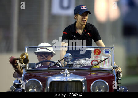 Motor Racing - Formula uno Singlel Singapore Grand Prix - gara - Marina Bay Circuit Park. Il pilota di Formula uno di Toro Rosso Sebastian Vettel è parato su una vettura d'epoca prima della gara Foto Stock