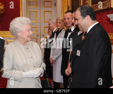 La Regina Elisabetta II della Gran Bretagna chats con Sir Stelios Haji-Ioannou, fondatore di easyGroup, al St James' Palace di Londra, in un ricevimento per celebrare il sessantesimo anniversario della disabilità del Cheshire Leonard. Foto Stock