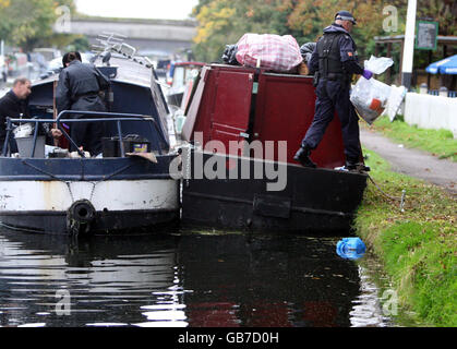 SI PREGA DI NOTARE CHE IL VOLTO SULL'UOMO ARRESTATO È STATO PIXELATED DALLA foto PA SU RICHIESTA DELLA POLIZIA UN uomo è arrestato da ufficiali della Metropolitan Police Marine Support Unit durante un raid di droga su due barche canale a Uxbridge, Middlesex. Foto Stock