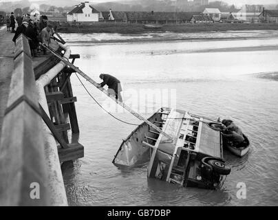 I lavoratori che si battono sopra l'autobus a due piani che è stato spazzato attraverso un ponte in un fiume 20 piedi sotto. 25 persone sono state intrappolate all'interno dell'autobus che viaggiava da Worthing a Brighton. Il fatto che la marea fosse bassa ha salvato i passeggeri dall'annegamento. Foto Stock