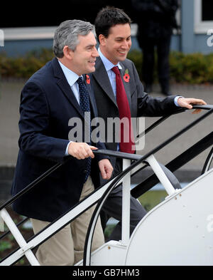 Il primo ministro Gordon Brown accompagnato dal segretario per l'energia e il cambiamento climatico ed Miliband si imbarca su un aereo diretto per il Medio Oriente, all'aeroporto di Heathrow, Londra. Foto Stock