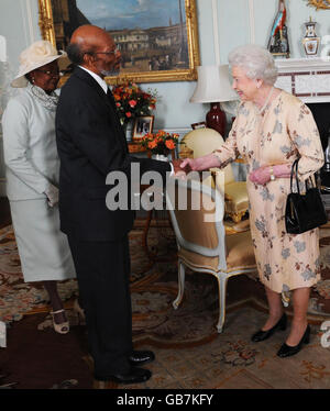 La Regina Elisabetta II della Gran Bretagna riceve Sir Daniel Williams sulla rinuncia alla sua nomina a Governatore Generale di Grenada accompagnato dalla moglie Lady Williams, a Buckingham Palace, nel centro di Londra. Foto Stock