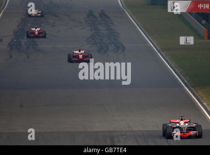 Lewis Hamilton della McLaren Mercedes si apre in testa ai piloti Ferrari Kimi Raikkonen e Felipe massa nei giri di apertura del Gran Premio Cinese di Formula uno Sinopec al circuito Internazionale di Shanghai, in Cina. Foto Stock