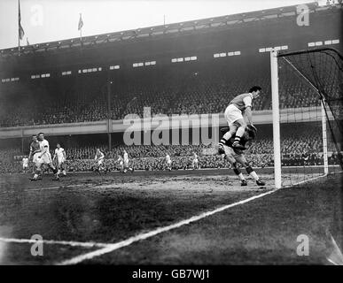 Calcio - Football League Division 1 - Arsenal contro Manchester United. Il portiere del Manchester United Harry Gregg (r) raccoglie la palla mentre i vici boschetti dell'Arsenale gli volano dentro Foto Stock