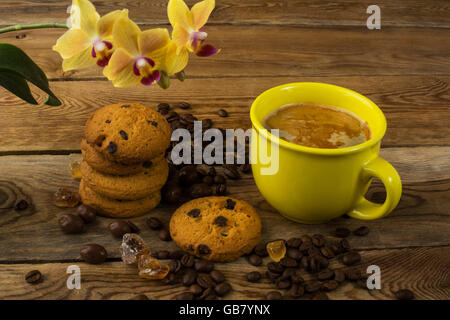 Tazza da caffè, biscotti e orchidea gialla. Tazza di caffè. Pausa caffè. Il caffè del mattino. Tazza da caffè Foto Stock