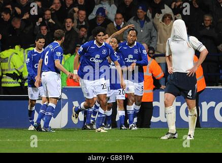 Marouane Fellaini (centro) di Everton celebra il primo obiettivo del gioco quasi a tempo pieno, mentre Kevin Nolan (a destra) di Bolton Wanderers sembra essere stato espulso. Foto Stock