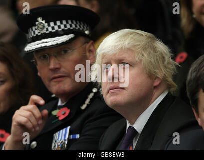 Il sindaco di Londra Boris Johnson siede accanto al vice commissario della polizia metropolitana Sir Paul Stephenson (a sinistra) al servizio annuale della polizia metropolitana per gli agenti di polizia e il personale che hanno perso la vita nel campo di servizio presso il Memorial Garden nel Peel Center, Hendon, Londra. Foto Stock