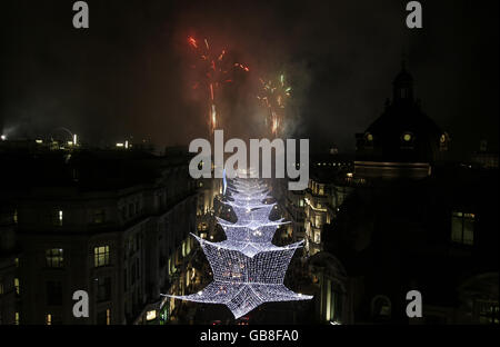 I fuochi d'artificio illuminano il cielo mentre McFly si accende le luci di Natale di Regent Street nel West End di Londra Foto Stock