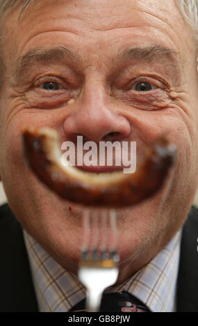 L'ex cricket umpire Dickie Bird partecipa alla valutazione del calore londinese del concorso 'Britain's Landmark Bangers', presso l'S&M Cafe di Shoreditch, Londra. Foto Stock