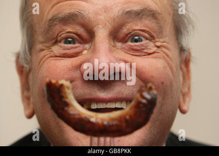 L'ex cricket umpire Dickie Bird partecipa alla valutazione del calore londinese del concorso 'Britain's Landmark Bangers', presso l'S&M Cafe di Shoreditch, Londra. Foto Stock