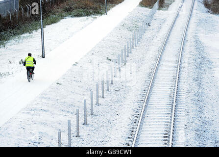 Un ciclista percorre un sentiero innevato nel North Tyneside, vicino a Newcastle, oggi, mentre un fronte artico ha colpito la costa orientale. Foto Stock