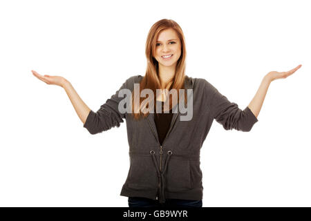 Donna adolescente presentare qualcosa su entrambi i palmi Foto Stock