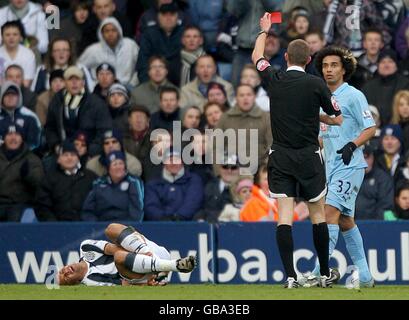 Il Benoit Assou-Ekotto di Tottenham Hotspur è indicato da una carta rossa Arbitro Steve Tanner dopo una sfida su West Bromwich Albion's. Gianni Zuiverloon (l) Foto Stock