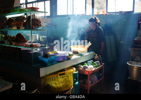 Lo Chef lavora al ristorante del riso, ella broit carne per com tam pasto, questo è specifico del cibo vietnamita di Dalat Foto Stock