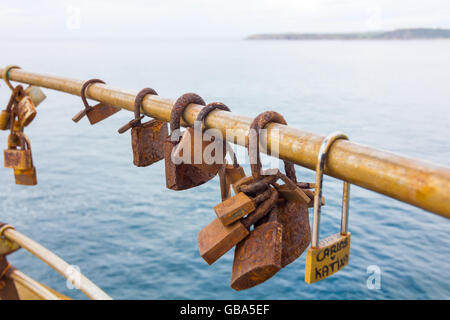 Rusty lucchetti su una ringhiera in riva al mare Foto Stock